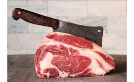 Raw prime rib beef with meat cleaver.