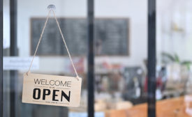 welcome we're open sign in front of store