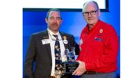 USPOULTRY president Nath Morris presents the Harold E. Ford Lifetime Achievement Award to former USPOULTRY president John Starkey at the 2024 IPPE