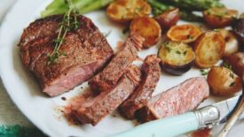 Ribeye sliced and plated with potatoes and asparagus