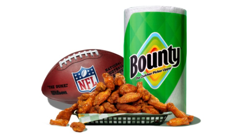 Bounty paper towels (right) next to a basket of chicken wings, and a football featuring the NFL logo (left)