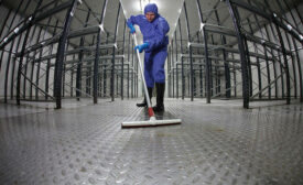 A contract sanitation worker cleaning a plant