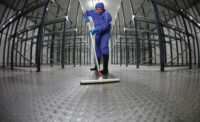 A contract sanitation worker cleaning a plant